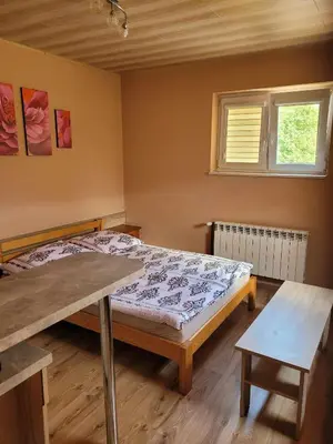 a bedroom with a bed and a table and a window at Jelonek Zawoja in Zawoja