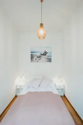 a white bedroom with a bed and a painting on the wall at Sight Main Square & Main Train Station & Planty in Kraków
