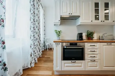 a kitchen with white cabinets and a stove top oven at Sight Main Square & Main Train Station & Planty in Kraków