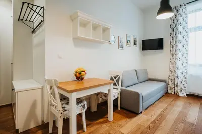 a living room with a table and a couch at Sight Main Square & Main Train Station & Planty in Kraków