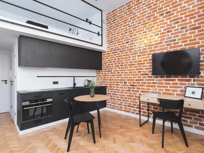 a kitchen with a brick wall and a table and chairs at City center - Radziwiłłowska 27 in Kraków