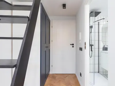 a hallway with an open door and a staircase at City center - Radziwiłłowska 27 in Kraków