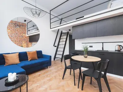 a living room with a blue couch and a table at City center - Radziwiłłowska 27 in Kraków