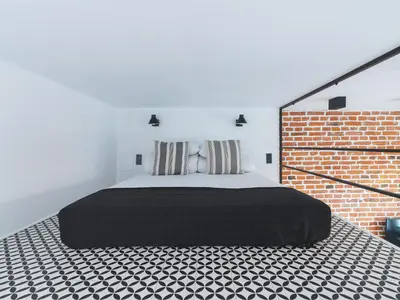 a bedroom with a bed and a brick wall at City center - Radziwiłłowska 27 in Kraków