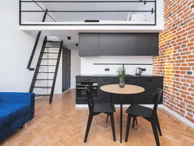 a kitchen with a table and a blue couch at City center - Radziwiłłowska 27 in Kraków