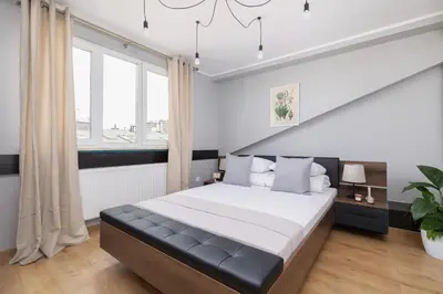 a bedroom with a large bed and a large window at Apartment with terrace - Skawińska 20 in Kraków