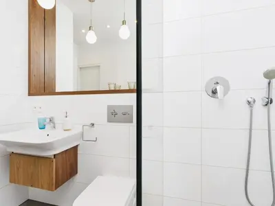 a white bathroom with a sink and a shower at Apartment with balcony - Pawia 34 Street in Kraków