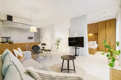 a living room and kitchen with a couch and a table at Terrace Apartment - Lubicz 17 street in Kraków