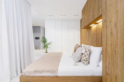 a bedroom with a bed with a wooden headboard at Terrace Apartment - Lubicz 17 street in Kraków