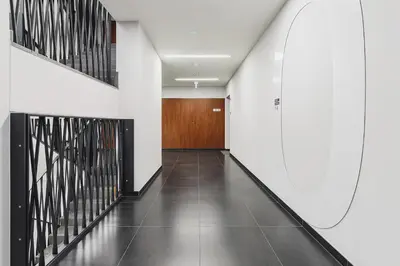 a hallway with white walls and a wooden door at Terrace Apartment - Lubicz 17 street in Kraków
