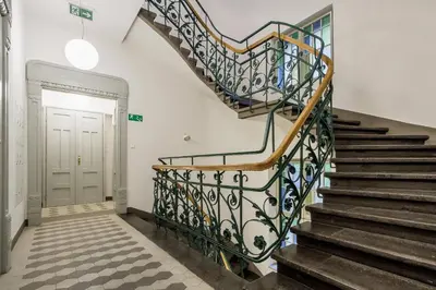 a staircase with a wrought iron railing in a hallway at Main Station - 8 Rakowicka Street in Kraków