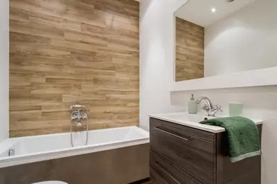 a bathroom with a tub and a sink and a mirror at Main Station - 8 Rakowicka Street in Kraków