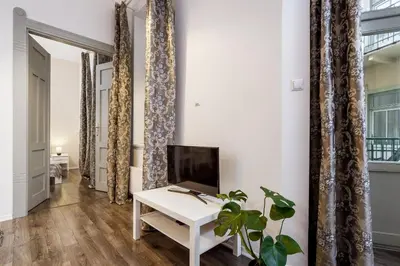 a living room with a white table and a tv at Main Station - 8 Rakowicka Street in Kraków