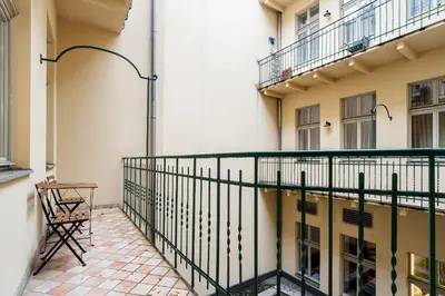 a balcony of a building with a table and a chair at Main Station - 8 Rakowicka Street in Kraków