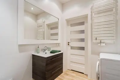 a white bathroom with a sink and a mirror at Main Station - 8 Rakowicka Street in Kraków