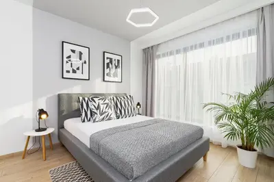 a white bedroom with a bed and a window at Apartment for two - Piłsudskiego 1 Street in Kraków