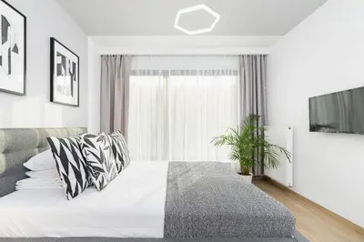 a white bedroom with a bed and a window at Apartment for two - Piłsudskiego 1 Street in Kraków