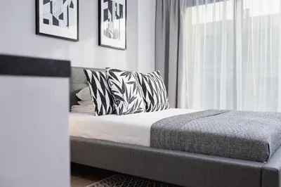 a bedroom with a bed with pillows and a window at Apartment for two - Piłsudskiego 1 Street in Kraków