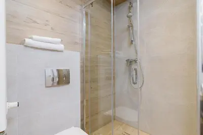 a bathroom with a shower with a glass door at Apartment for two - Piłsudskiego 1 Street in Kraków