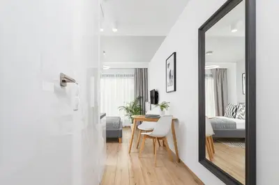a mirror in a room with a table and a bedroom at Apartment for two - Piłsudskiego 1 Street in Kraków