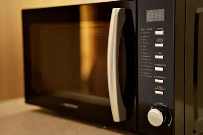 a black microwave oven with a white handle at Magic Apartments - Siena in Zator