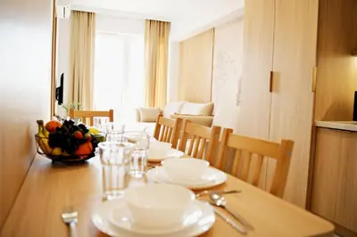 a dining room table with white dishes on it at Magic Apartments - Siena in Zator