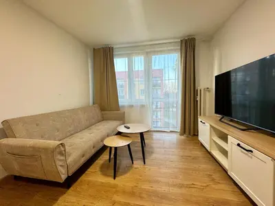a living room with a couch and a flat screen tv at Apartament Bałandy 26 in Oświęcim