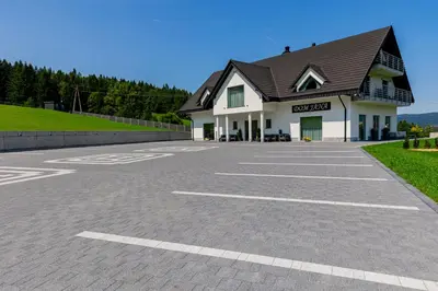 a parking lot in front of a building at Kompleks Gazdówka - Dom Jana in Ponice