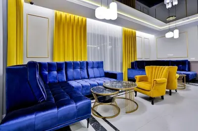 a living room with a blue couch and yellow chairs at Kompleks Gazdówka - Dom Jana in Ponice