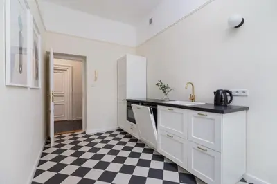 a kitchen with a black and white checkered floor at 3-Bedroom Apartment - Rejtana 10 in Kraków