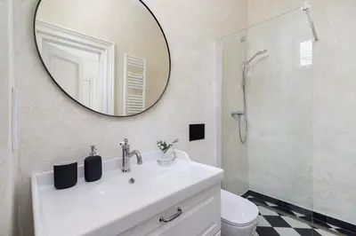 a bathroom with a white sink and a mirror at 3-Bedroom Apartment - Rejtana 10 in Kraków