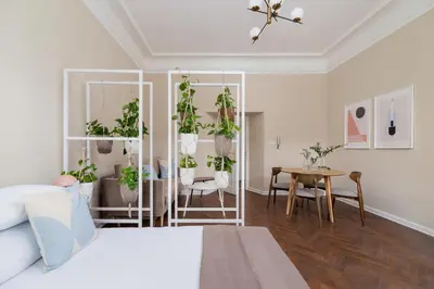 a bedroom with a bed and a table with plants at 3-Bedroom Apartment - Rejtana 10 in Kraków