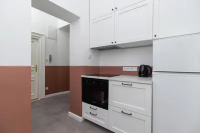 a kitchen with white cabinets and a stove top oven at 2-Bedroom Apartment - Rejtana 10 in Kraków