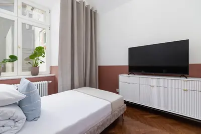 a bedroom with a bed and a flat screen tv at 2-Bedroom Apartment - Rejtana 10 in Kraków
