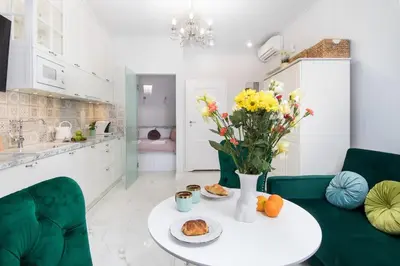 a kitchen with a table with a vase of flowers at 1 - bedroom Apartment - Plac na Groblach 19 in Kraków