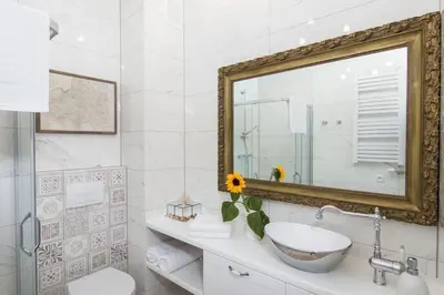 a white bathroom with a sink and a mirror at 1 - bedroom Apartment - Plac na Groblach 19 in Kraków