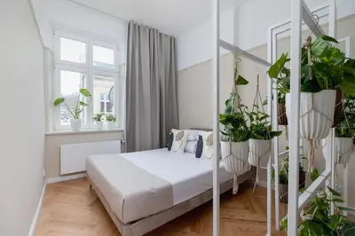 a bedroom with a bed and lots of plants at 2 - bedroom Apartment - Rejtana 10 in Kraków