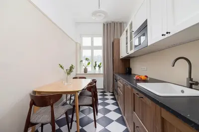a kitchen with a table and chairs and a sink at 2 - bedroom Apartment - Rejtana 10 in Kraków