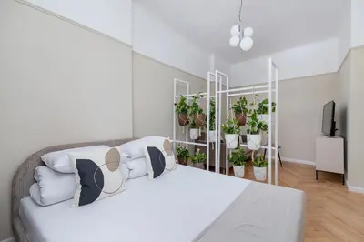 a bedroom with a bed with plants on the wall at 2 - bedroom Apartment - Rejtana 10 in Kraków