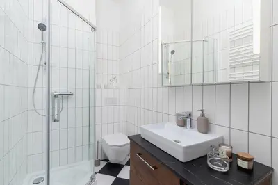 a bathroom with a sink and a shower and a toilet at 2 - bedroom Apartment - Rejtana 10 in Kraków