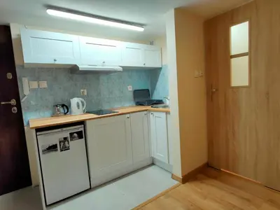 a kitchen with white cabinets and a counter top at Krakow Old Town Apartment in Kraków