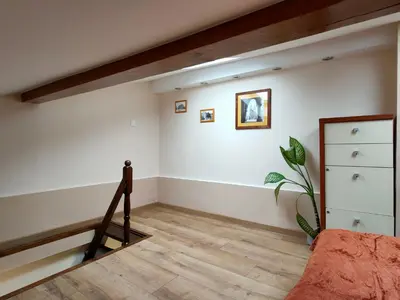 an attic room with a staircase and a dresser at Krakow Old Town Apartment in Kraków