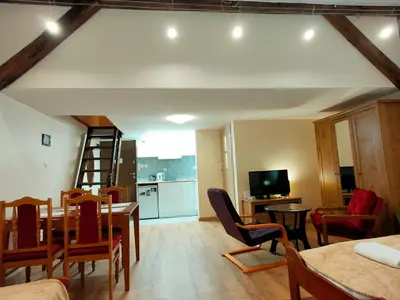 a living room with a table and chairs and a kitchen at Krakow Old Town Apartment in Kraków