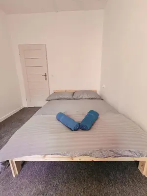 an empty room with a door and a kitchen with a refrigerator at Cool and big room in Krakow in Kraków