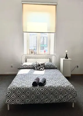 a bedroom with a bed with two slippers on it at Cool and big room in Krakow in Kraków
