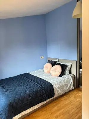a blue bedroom with a bed with two pillows at Blue Moon Main Square Apartment in Kraków
