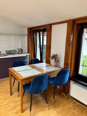 a kitchen with a wooden table and blue chairs at Blue Moon Main Square Apartment in Kraków