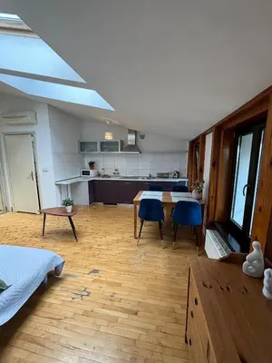 a large kitchen with a table and blue chairs at Blue Moon Main Square Apartment in Kraków