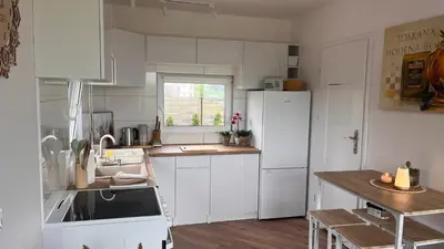 a kitchen with white cabinets and a white refrigerator at Riwiera Strzelecka in Strzelce Małe