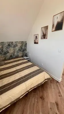 a bedroom with a bed and three pictures on the wall at Riwiera Strzelecka in Strzelce Małe